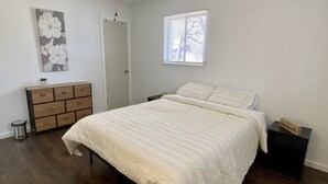 Une chambre à coucher avec un lit, une commode et un ventilateur de plafond.