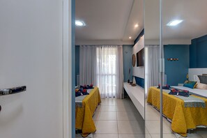 A hotel room with two beds, a large mirror, and a view of the street.