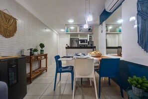 Een moderne keuken met witte kasten, een ingebouwde magnetron en een koffieapparaat.
