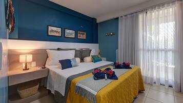 Quarto de hotel com cama, mesa de cabeceira, luminária e obra de arte na parede.
