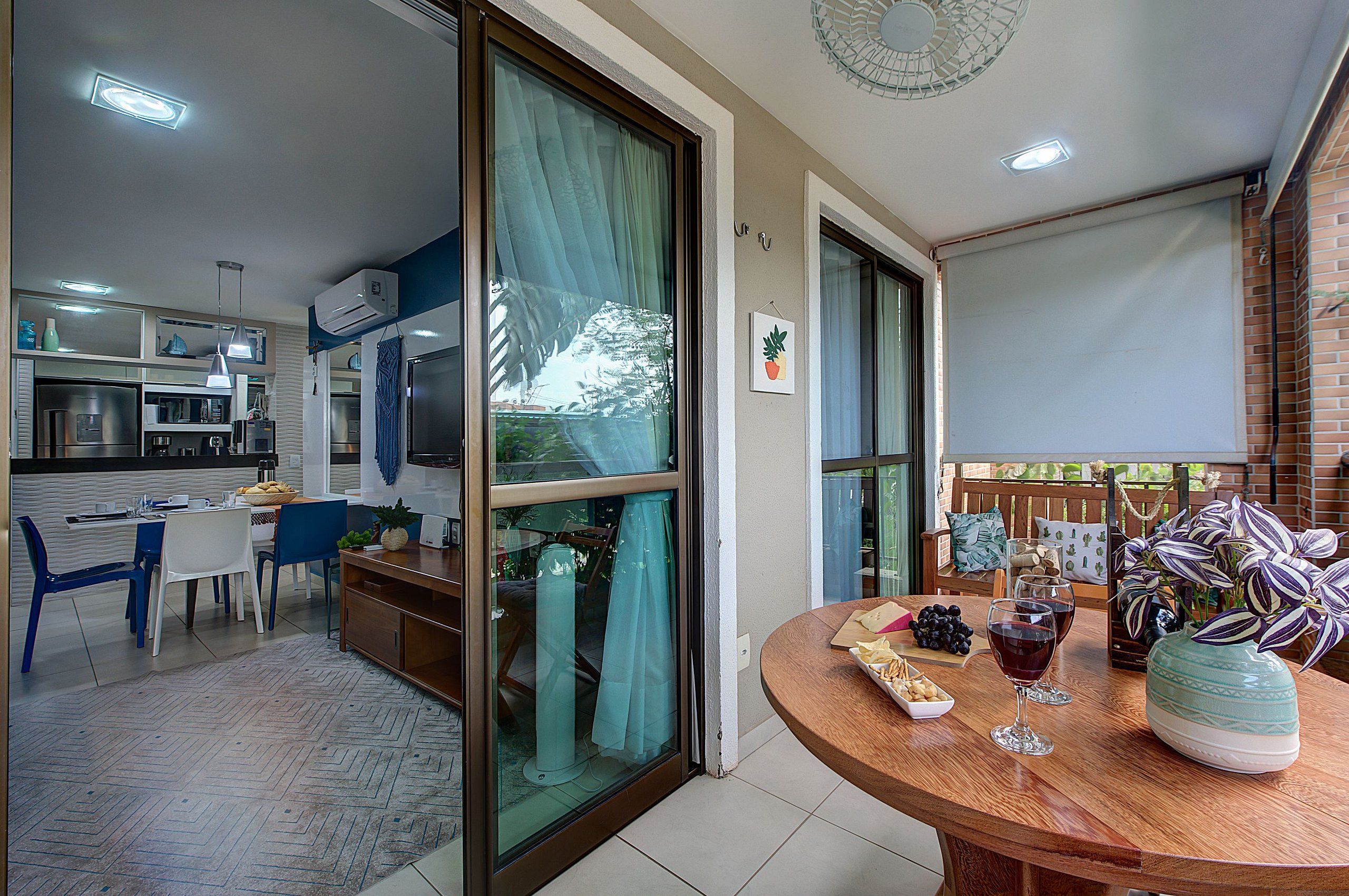 Cozinha moderna com área de refeições, varanda com vista e mesa posta.