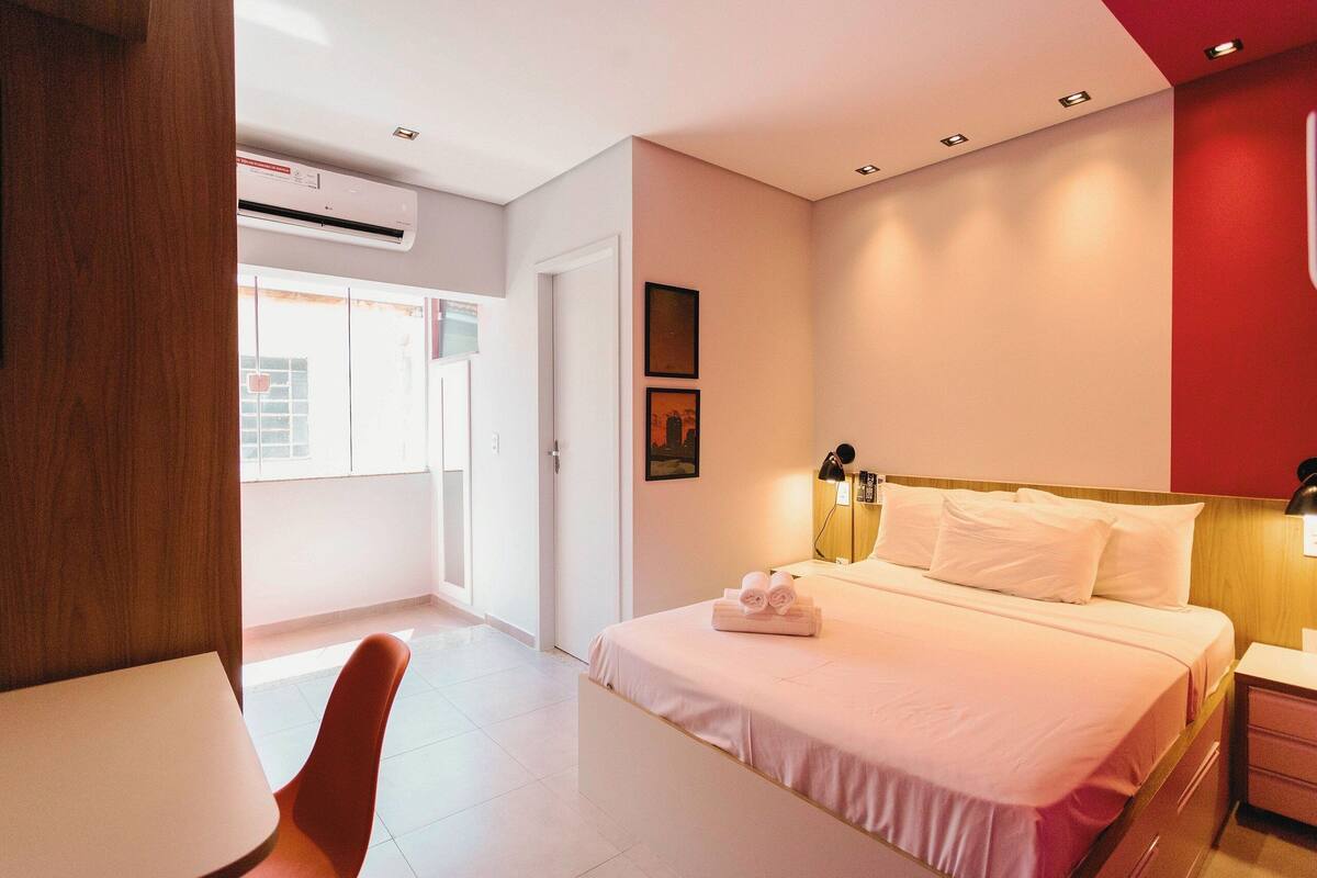 Une chambre d’hôtel avec un lit, une table de chevet et une fenêtre.