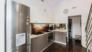 A modern kitchen with stainless steel appliances, a black sink, and a wooden countertop. - Beach front home in Vinisce with sauna (Vinisce)