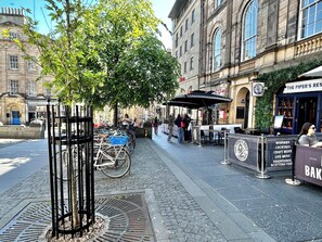 A cobblestone street with a café named "The Piper's Rest" offering drinks and music. - Economical 2 bedroom property just off the famous Royal Mile (Edinburgh)