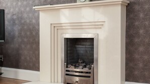 A fireplace with a white mantel and a clock above it.