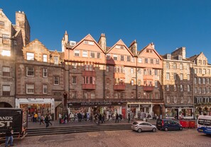 A historic building with multiple stories, featuring traditional architecture with stone facades and red-tiled roofs.