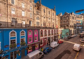 A street view with historic buildings, cobblestone road, and parked vehicles. - Wonderful 1 bedroom + sofabed in the heart of the Old Town (Edinburgh)
