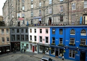 A row of multi-story buildings with various shops on the ground floor.