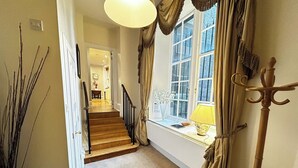 Ein Flur mit Teppich und einer Treppe, die zu einem Zimmer führt.