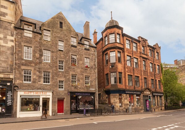 A street view with buildings, including a milk bar and a store named Purple Glamour.