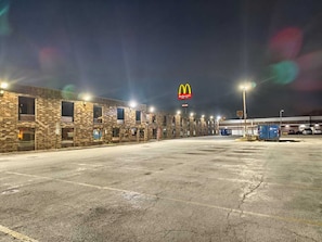 A McDonald's restaurant with a brick facade, multiple windows, and a parking lot.
