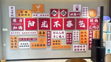Una pared con varios carteles y símbolos, incluyendo un vaso de cóctel, un corazón y un logotipo con la letra 'H'.