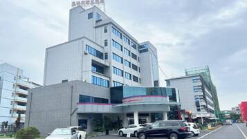 A multi-story building with a parking lot in front.