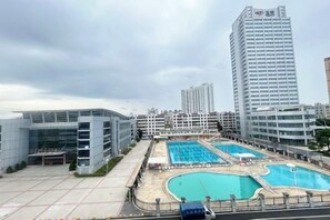 A modern hotel with multiple floors, a swimming pool, and a parking area. - Yulin Hotel (Yuchai Shop) (Yulin)