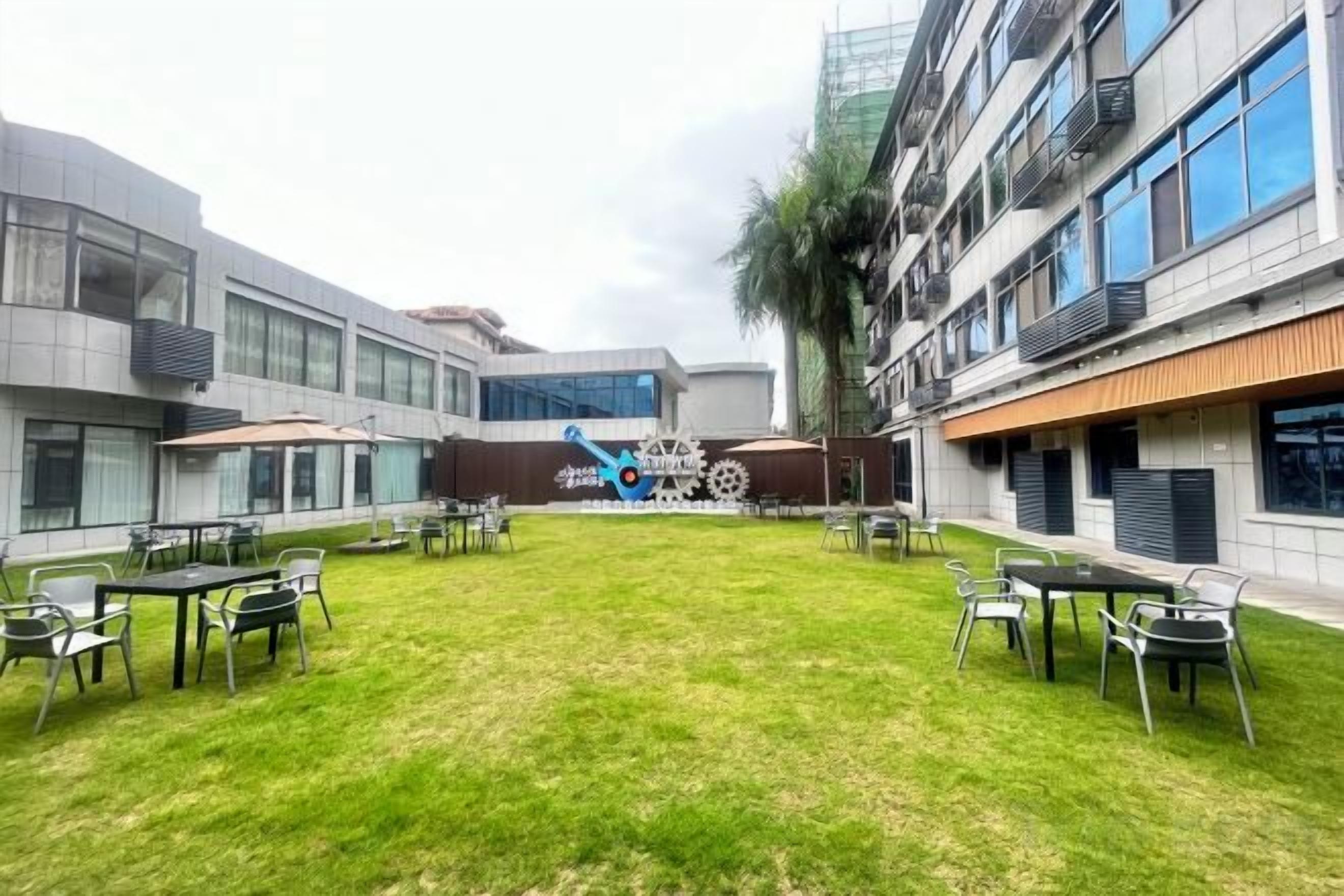 A courtyard with outdoor seating and a central sculpture.