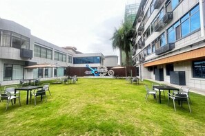 A courtyard with outdoor seating and a central sculpture. - Yulin Hotel (Yuchai Shop) (Yulin)