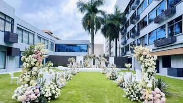 Une cour agrémentée d’un arrangement floral et, en arrière-plan, un bâtiment moderne.