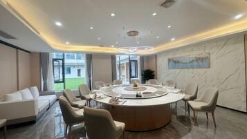 A modern conference room with a round table, chairs, and a sofa.