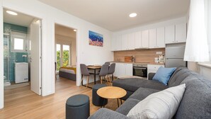 Eine moderne Wohnung mit Wohnzimmer, Essbereich, Küchenzeile und einem Balkon mit Blick.