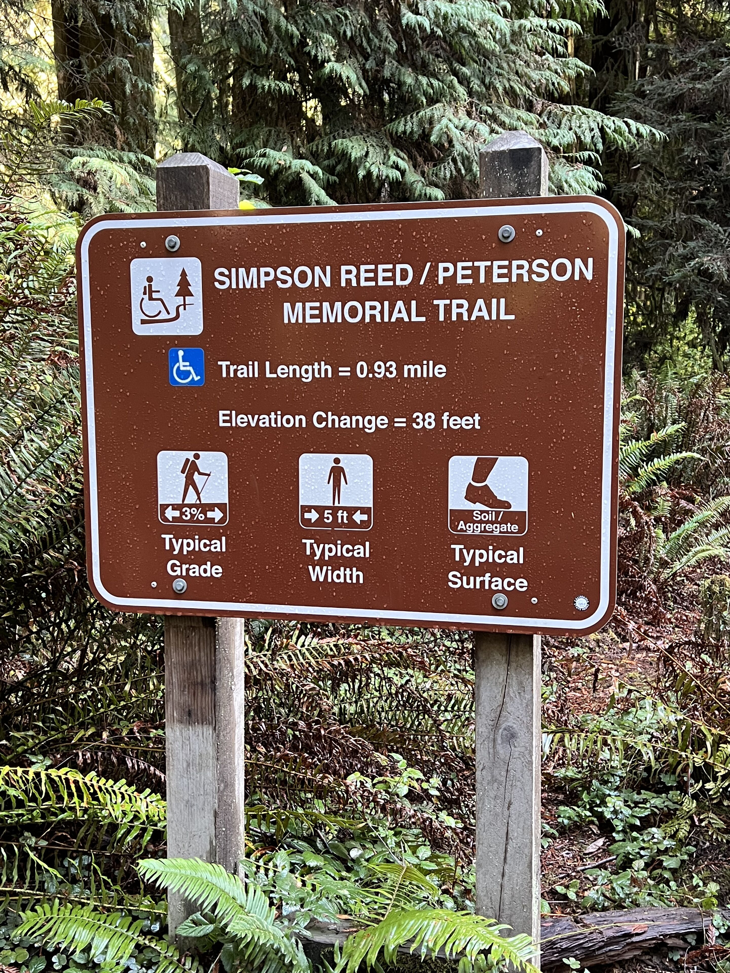 A sign for the Simpson Reed / Peterson Memorial Trail, indicating a 0.93-mile length, 38 feet elevation change, 3% grade, 5 feet width, and a typical surface of soil/aggregate.