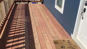 A wooden deck with a metal railing, a door with a peephole, and a doormat with paw prints. - "Woof"  Lodge  minutes from the Beach and Redwoods (Crescent City)