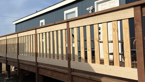 A building with a wooden deck and a garage door. - "Woof"  Lodge  minutes from the Beach and Redwoods (Crescent City)