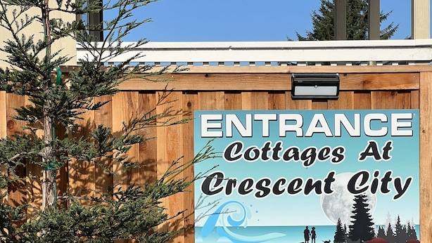 A wooden fence with a sign reading "Entrance Cottages At Crescent City." - "Woof"  Lodge  minutes from the Beach and Redwoods (Crescent City)