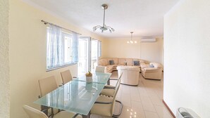 A dining area with a glass table and chairs, a sofa set, and a ceiling fan. - Nice home in Okrug Gornji with sauna (Okrug Gornji)