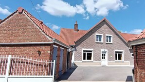 A brick building with a red-tiled roof, a gated entrance, and a sign indicating room number 22.