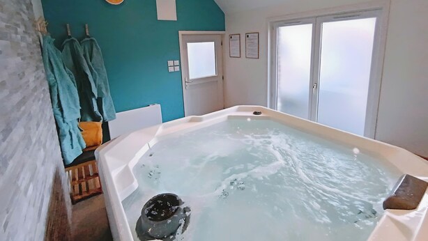 A bathroom with a bathtub, towels, and a shower area.