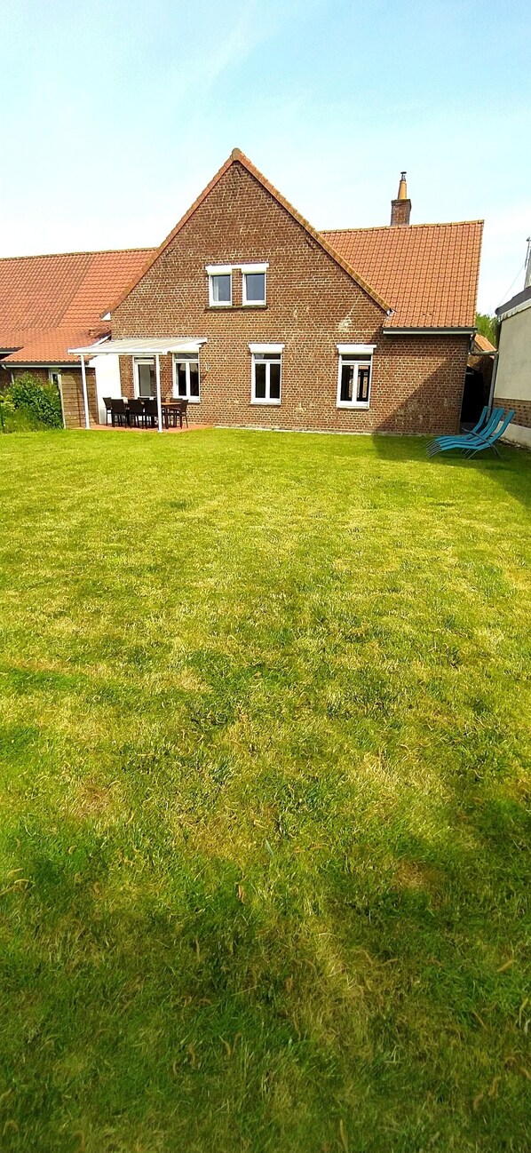 A house with a brick exterior, a tiled roof, and a large lawn in front. - "Le L'Arsène," 3-star, sleeps 6–8, with a private spa in the countryside near St-Omer (Wardrecques)