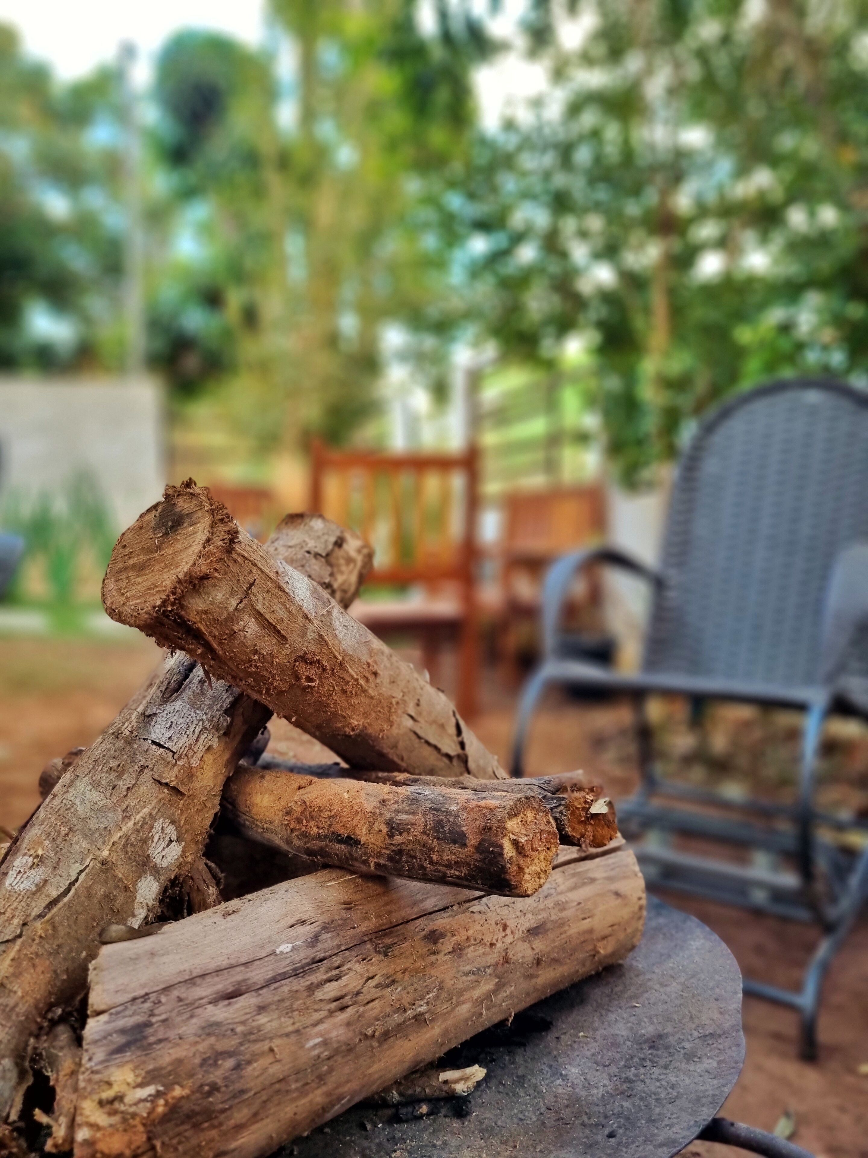 Ein Stapel Holzscheite auf einer Metallplatte im Freien.