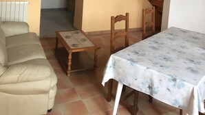 A dining area with a table and chairs, a wooden staircase, and a sofa. - Superb gîte in the Bordeaux countryside (Saint-Vivien-de-Blaye)
