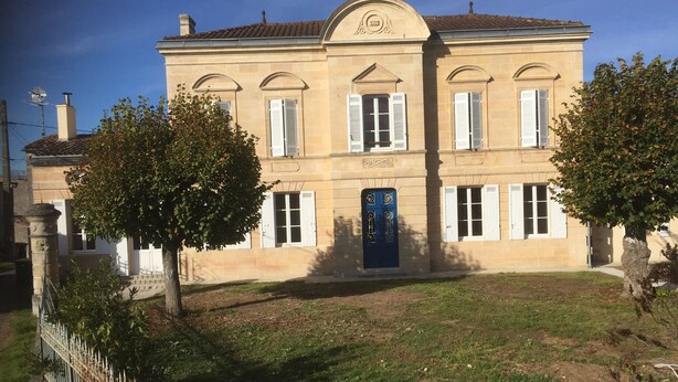 A two-story building with a symmetrical facade, large windows with shutters, and a central entrance with a decorative door. - Superb gîte in the Bordeaux countryside (Saint-Vivien-de-Blaye)