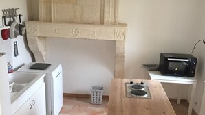 A kitchen with white cabinets, a wooden countertop, a microwave, and a washing machine. - Superb gîte in the Bordeaux countryside (Saint-Vivien-de-Blaye)