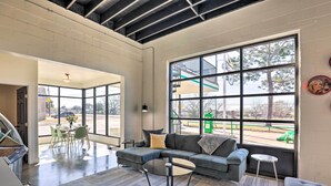 Una habitación amplia con un sofá seccional grande, una mesa redonda y una zona de comedor con sillas y mesa.