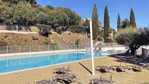 A swimming pool with lounge chairs and a view of trees and hills. - In estate with swimming pool, tennis, club house, house for 6 people, sea view (SAINTE MAXIME)