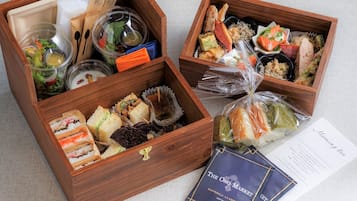 Dos cajas de madera con diversos alimentos y una tarjeta de presentación.