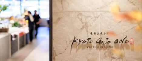 L’intérieur d’un restaurant avec un mur en marbre et une enseigne indiquant « Kyoto Gojo Ono ».