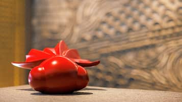 A red object with a star-like top on a textured surface.