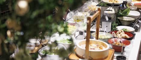A buffet with various dishes and a Christmas tree in the foreground.