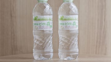 Dos botellas de agua mineral natural con etiqueta que muestra pasto y el texto 'Agua Mineral Natural'.