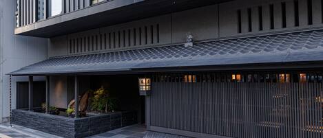 A modern building with a flat roof, large windows, and a stone base.