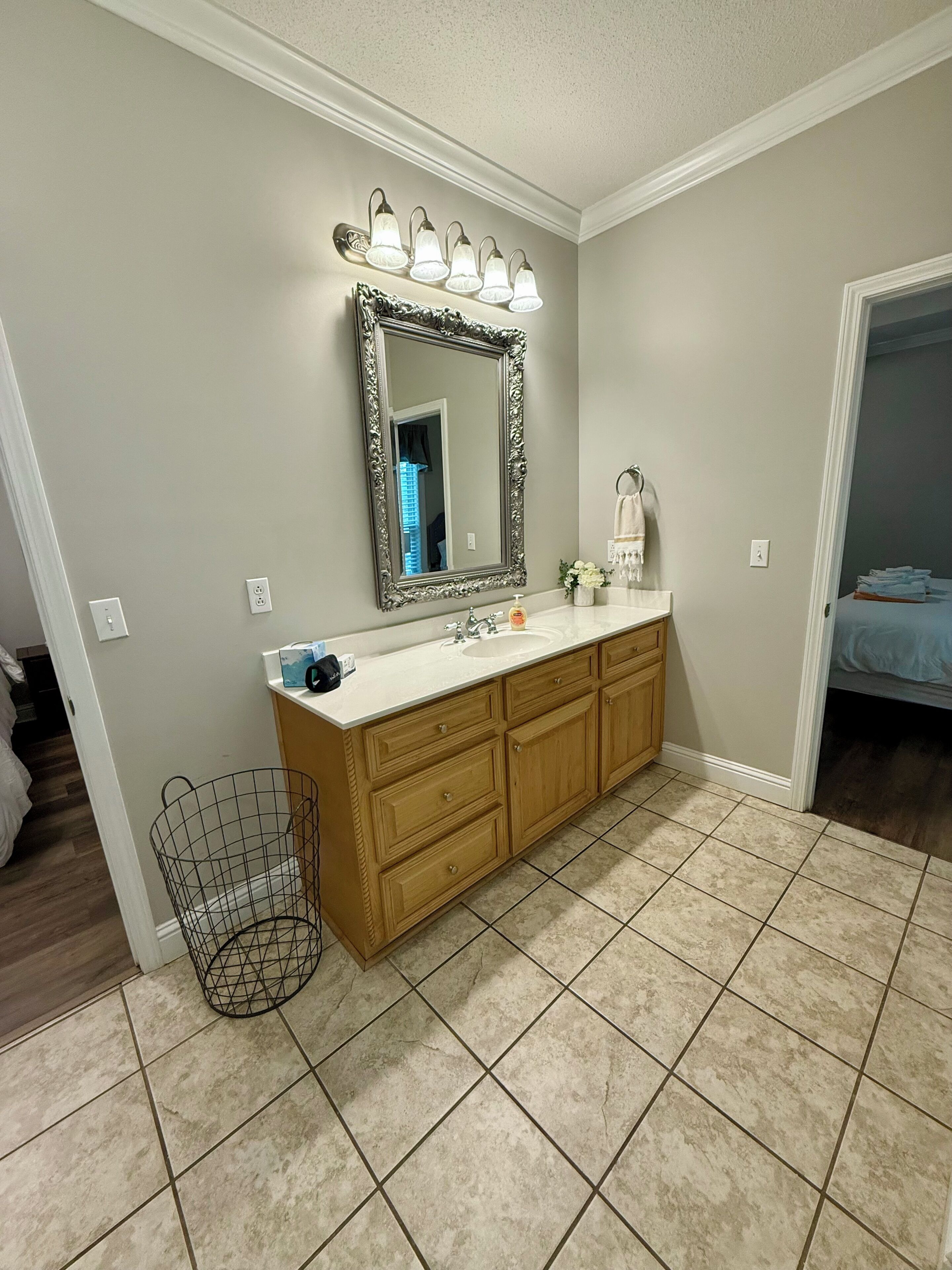 Une salle de bain avec un meuble-lavabo double, un grand miroir et un luminaire au-dessus.