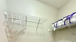 Un placard de rangement avec des étagères en métal et un banc noir.