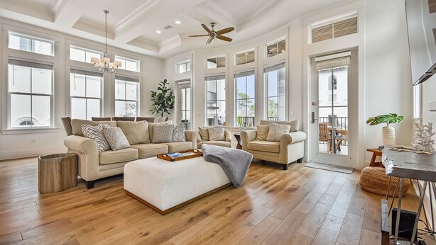 A spacious living room with a large sectional sofa, a coffee table, and a dining area with a table and chairs.