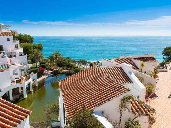 Une propriété située sur la côte, dotée d’un toit en tuiles de terre cuite, d’une piscine et offrant une vue sur la mer.