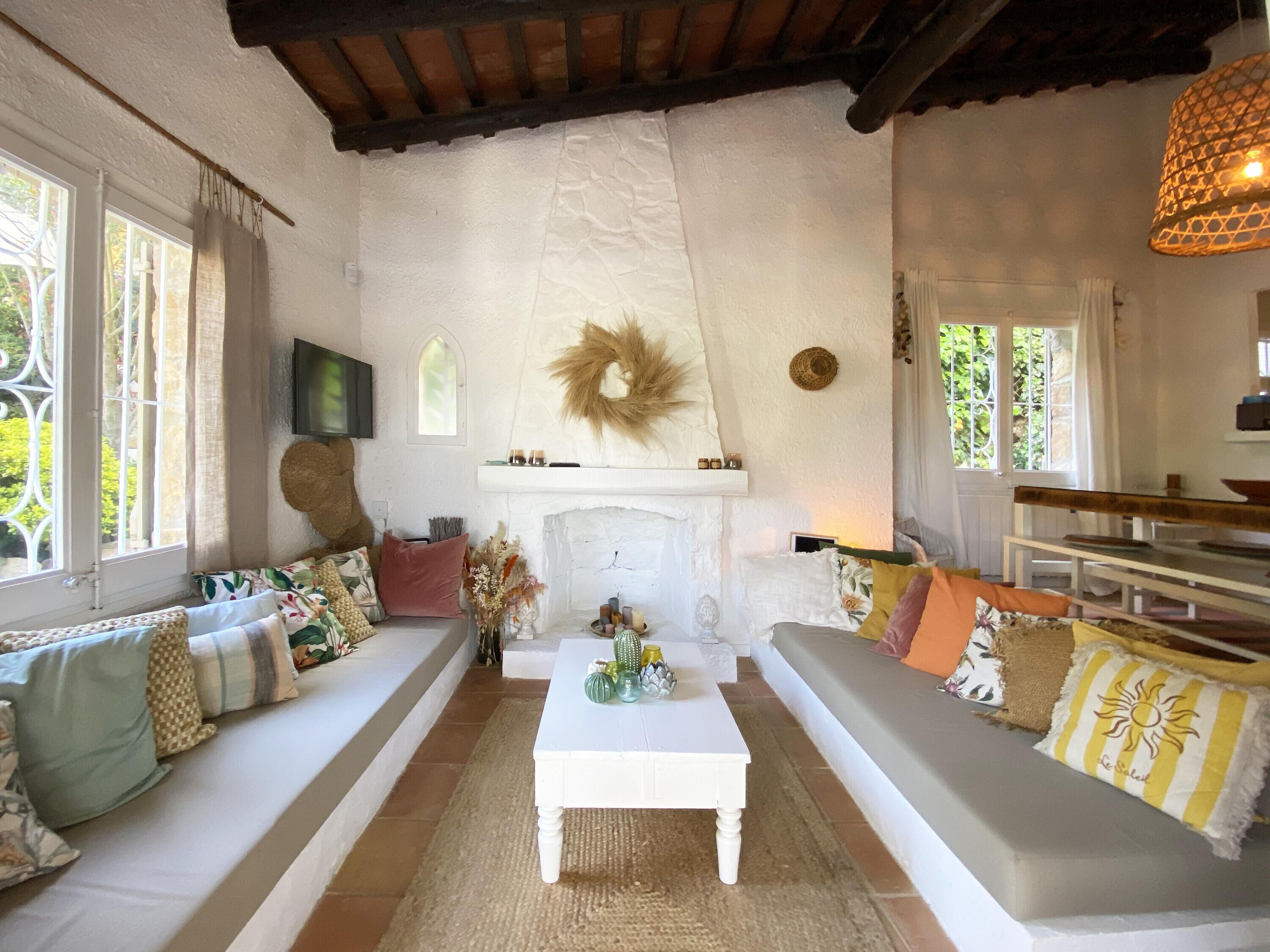 Una sala de estar acogedora con chimenea, un conjunto de sofás y un comedor.