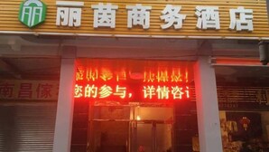 Ein Hotel Eingang mit einer auffälligen Beschilderung und einem roten Neonzeichen über der Tür.