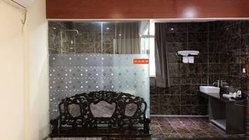A bathroom with a black sink, a mirror, and a bench.